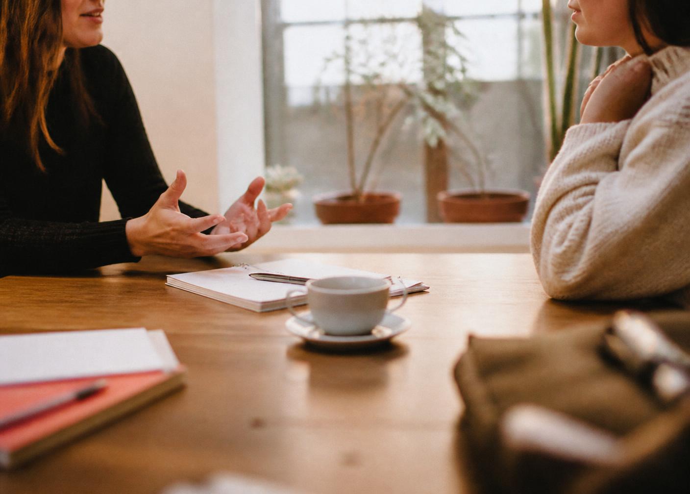 Two people talking at a table during a coaching conversation